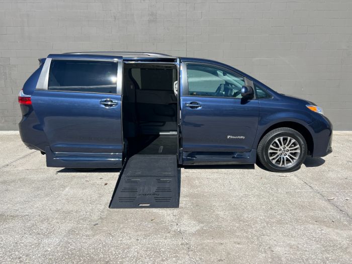 Blue Toyota Sienna Wheelchair Van with ramp deployed from open passenger side sliding door.