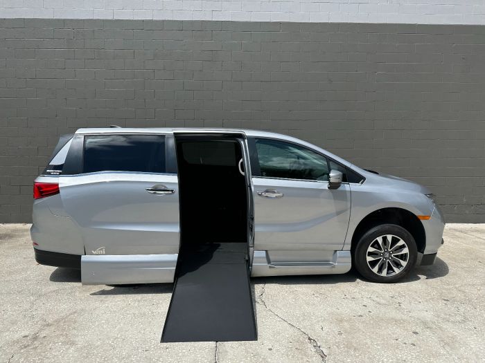 Silver Honday Odyssey wheelchair van with in floor ramp wheelchair van conversion deployed from open passenger sliding door.