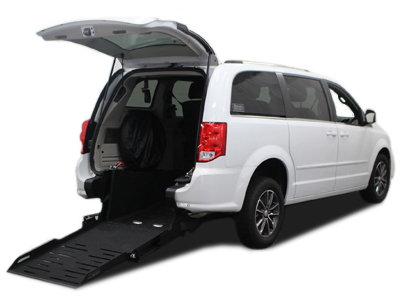 A white Dodge Grand Caravan with AMS rear entry conversion with ramp deployed from open rear hatch.