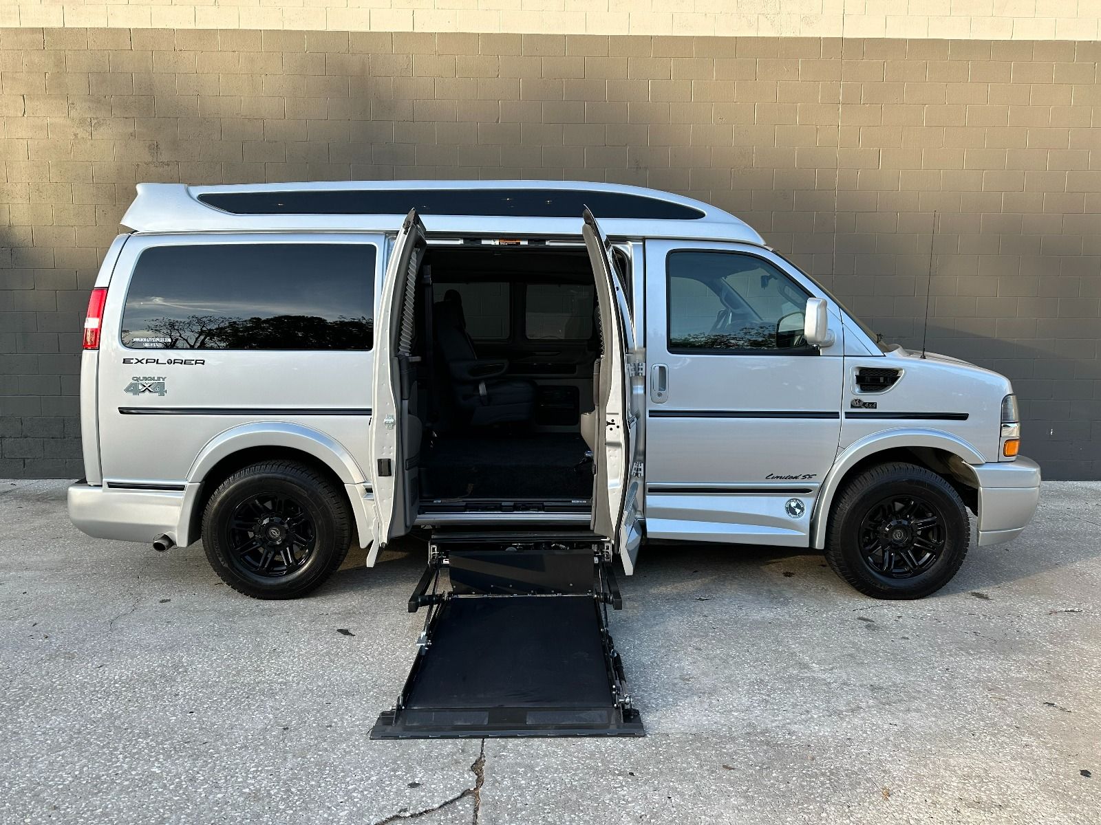 Chevrolet Express Full Size Wheelchair Van with lift system deployed from passenger side barn style doors.