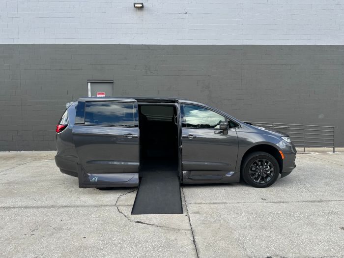 Gray Chrysler Pacifica with in floor ramp wheelchair van conversion deployed from open passenger sliding door.