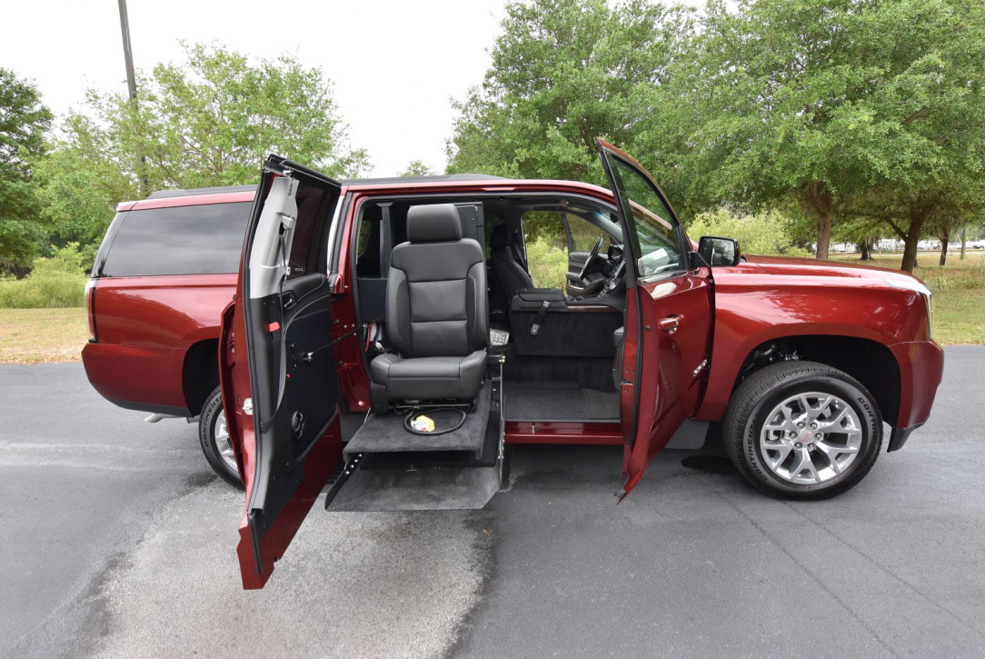 White Honda Odyssey wheelchair van with the ramp deployed from the open passenger side sliding door.