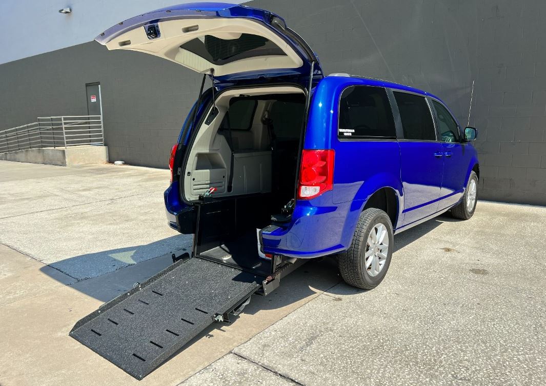 A blue Dodge Grand Caravan with Ryno Mobility Rear Entry Conversion with ramp deployed from rear hatch.